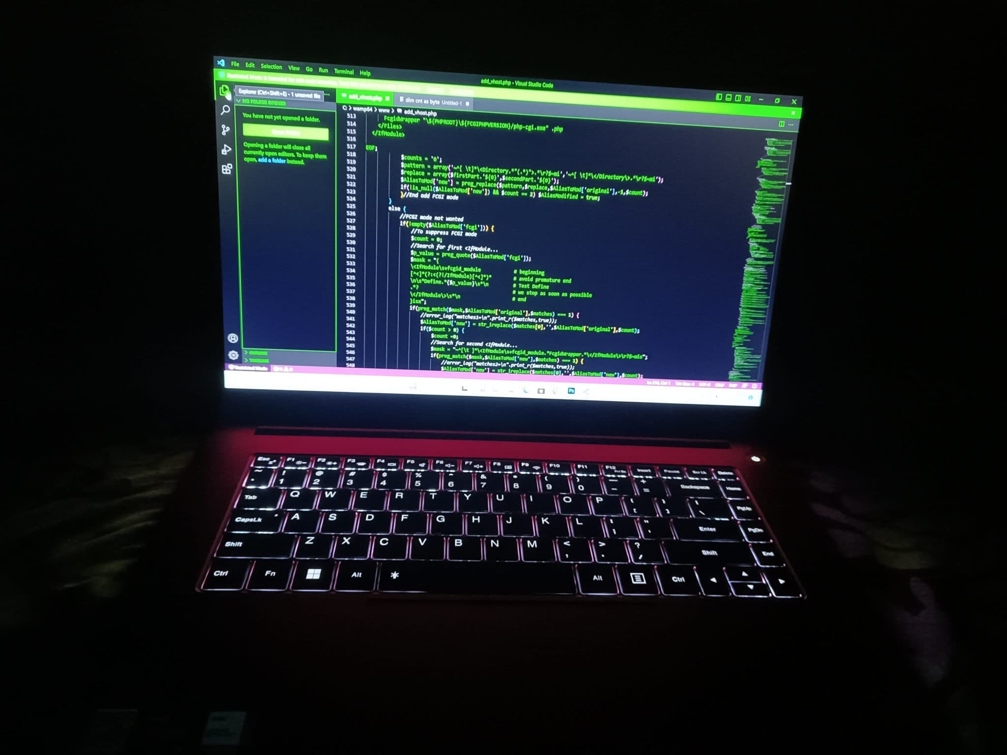 A laptop showing green code in a dark room