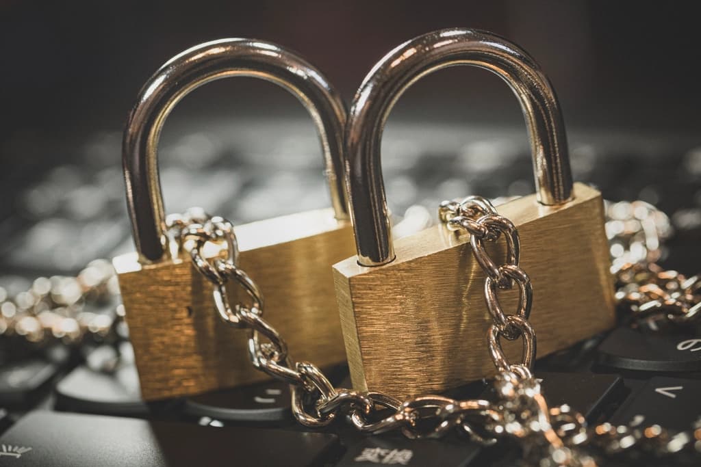 Two padlocks chained together on a laptop keyboard